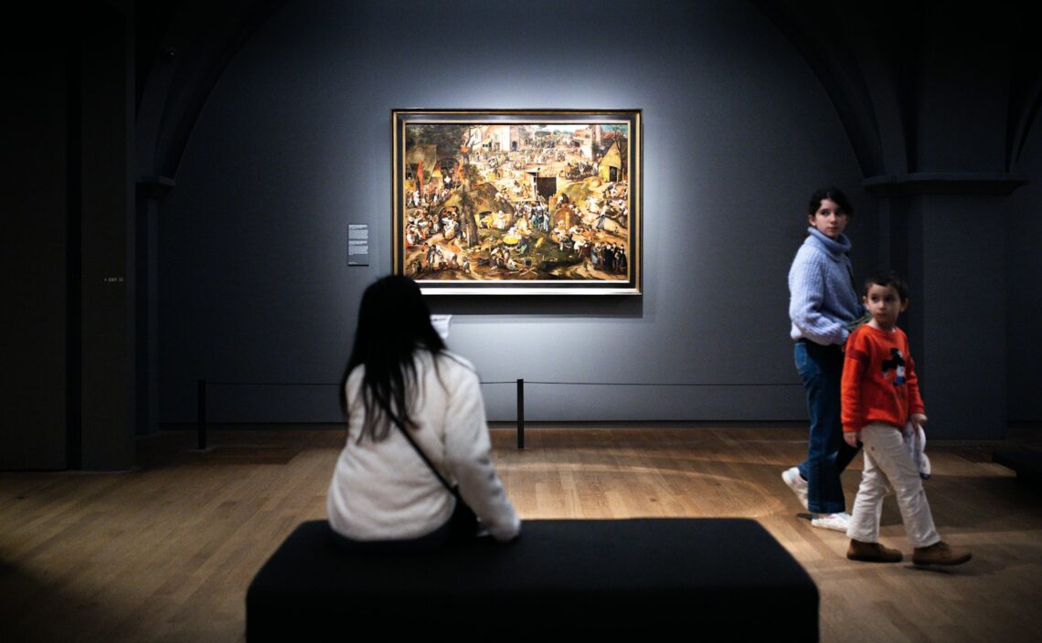 Mor og barn står sammen og kigger på et maleri på et kunstmuseum