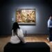Mor og barn står sammen og kigger på et maleri på et kunstmuseum